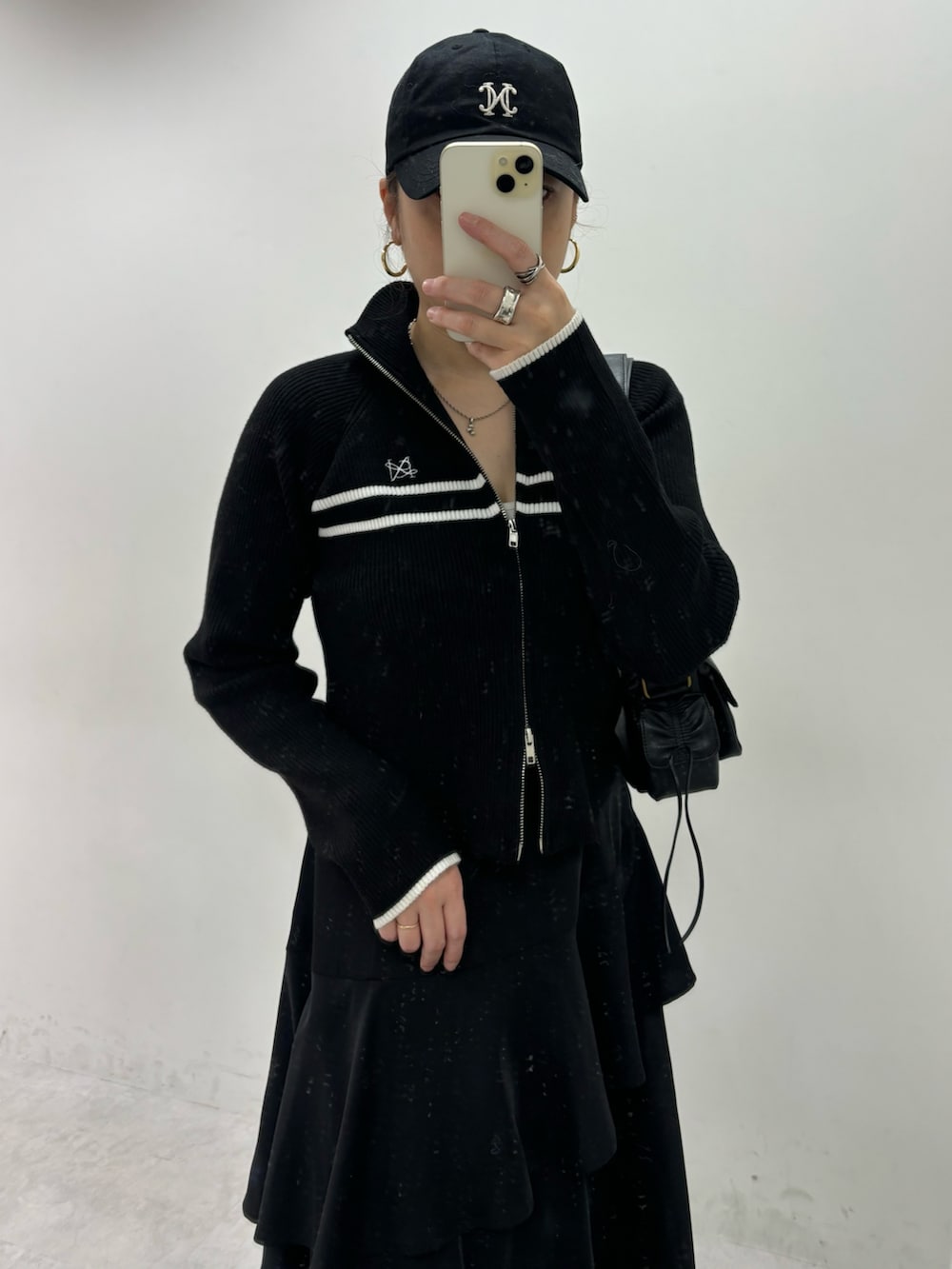 ブラック系のスカート、ブラック系のニット/セーター、グレー系のスニーカーを着用したレディースの秋コーディネートの4枚目の写真