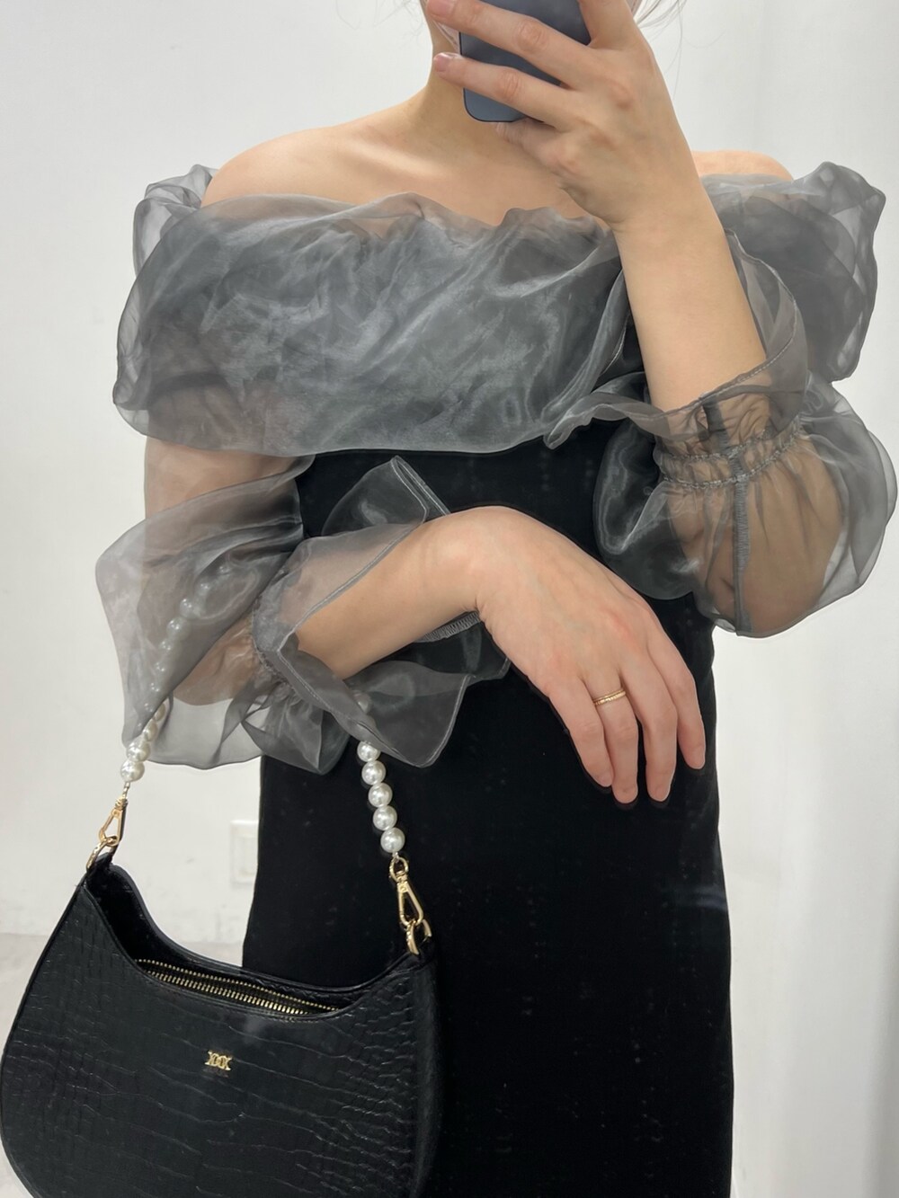 ブラック系のワンピース、ホワイト系のショルダーバッグ、ピンク系のシャツ/ブラウスを着用したレディースの冬コーディネートの2枚目の写真