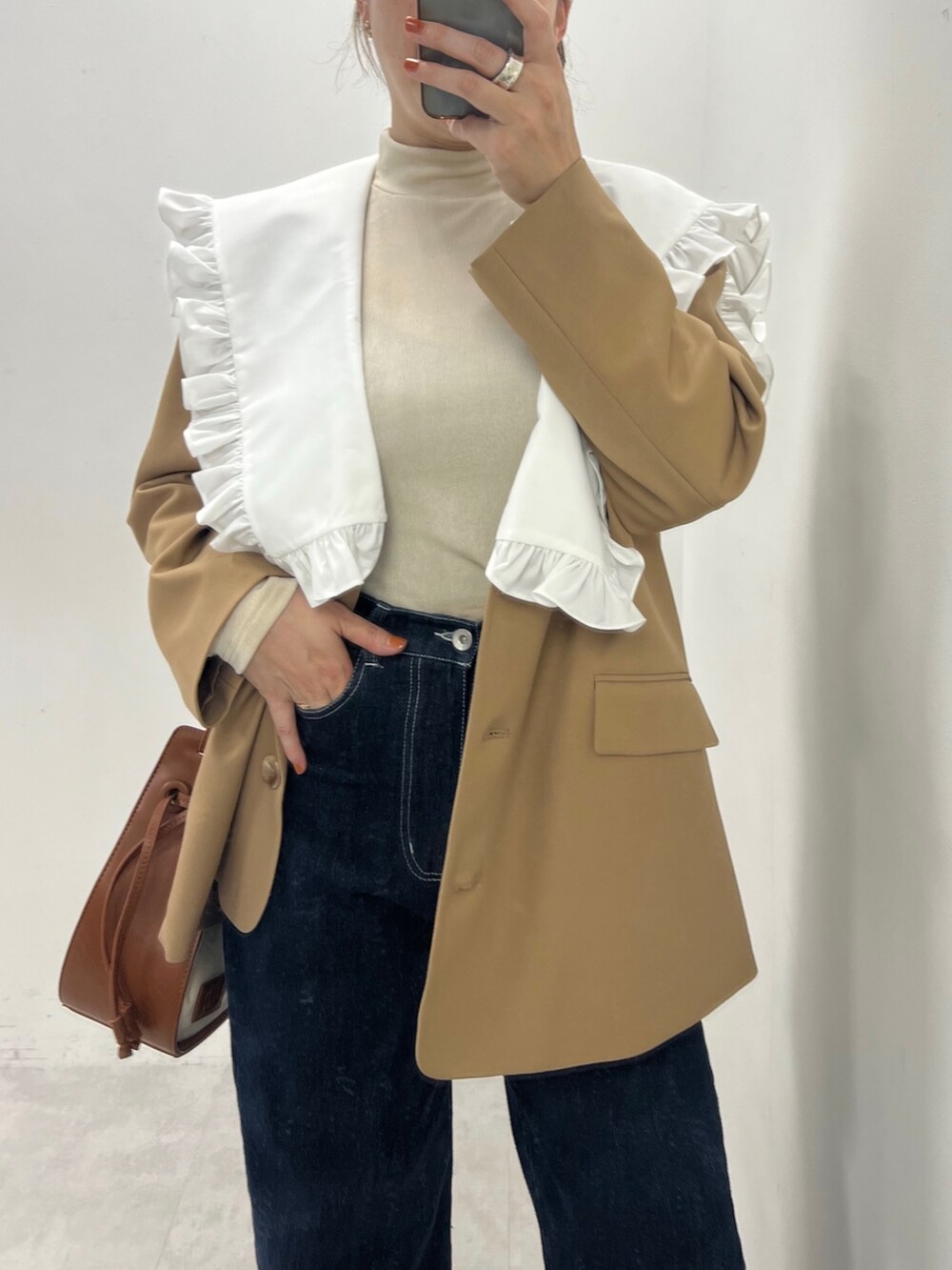 ブルー系のデニムパンツ、ブラウン系のテーラードジャケット、ホワイト系のシャツ/ブラウスを着用したレディースの夏コーディネートの2枚目の写真