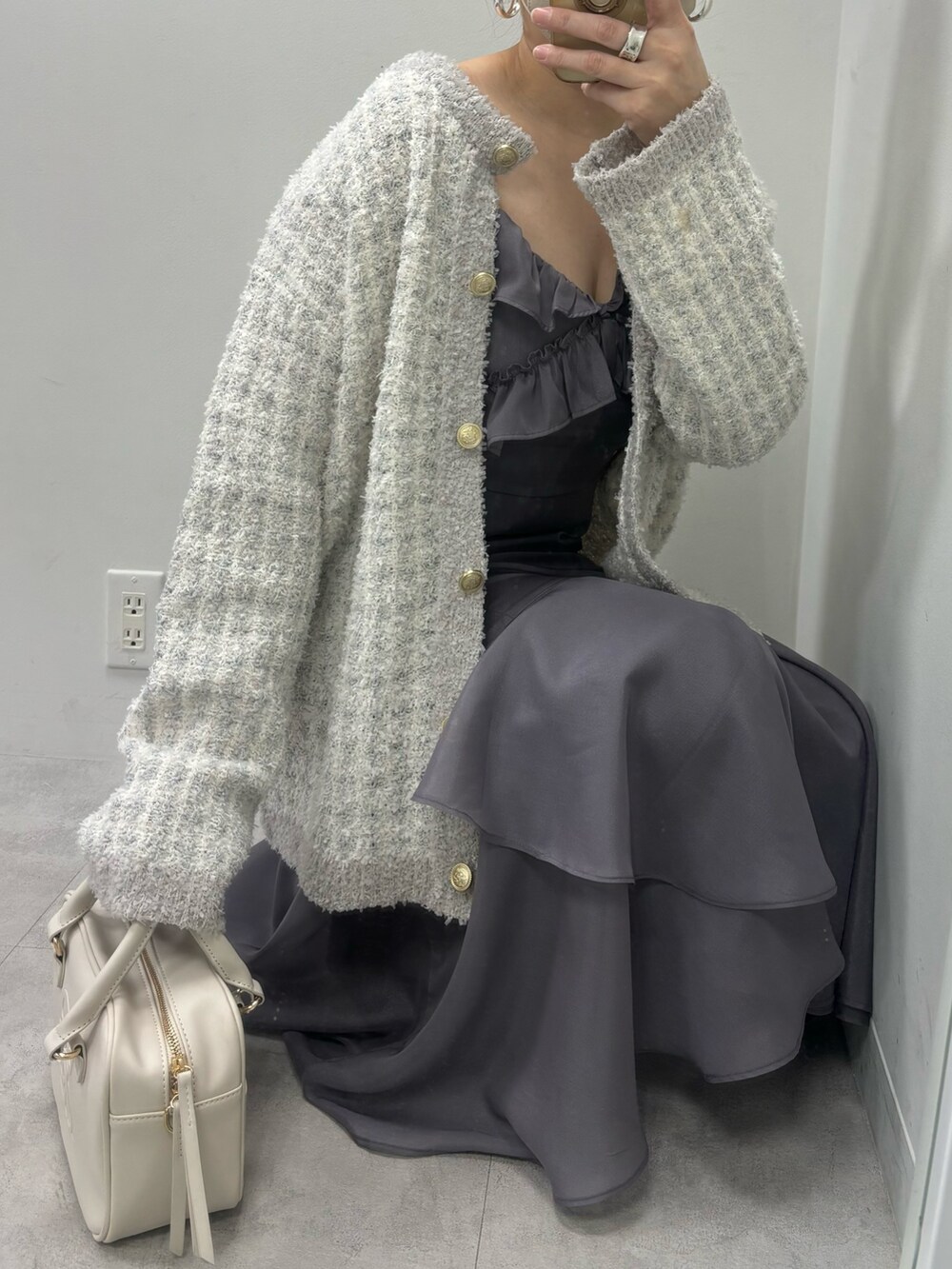 グレー系のワンピース、ブルー系のカーディガン/ボレロ、イエロー系のボストンバッグを着用したレディースの冬コーディネートの3枚目の写真