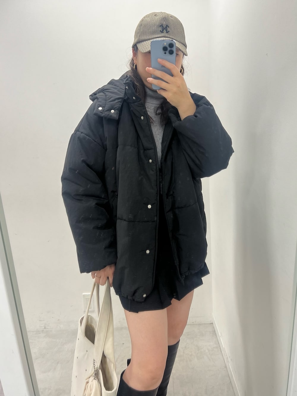 ピンク系のダウンジャケット/コート、グレー系のニット/セーター、ブラック系のブーツを着用したレディースの秋コーディネートの2枚目の写真