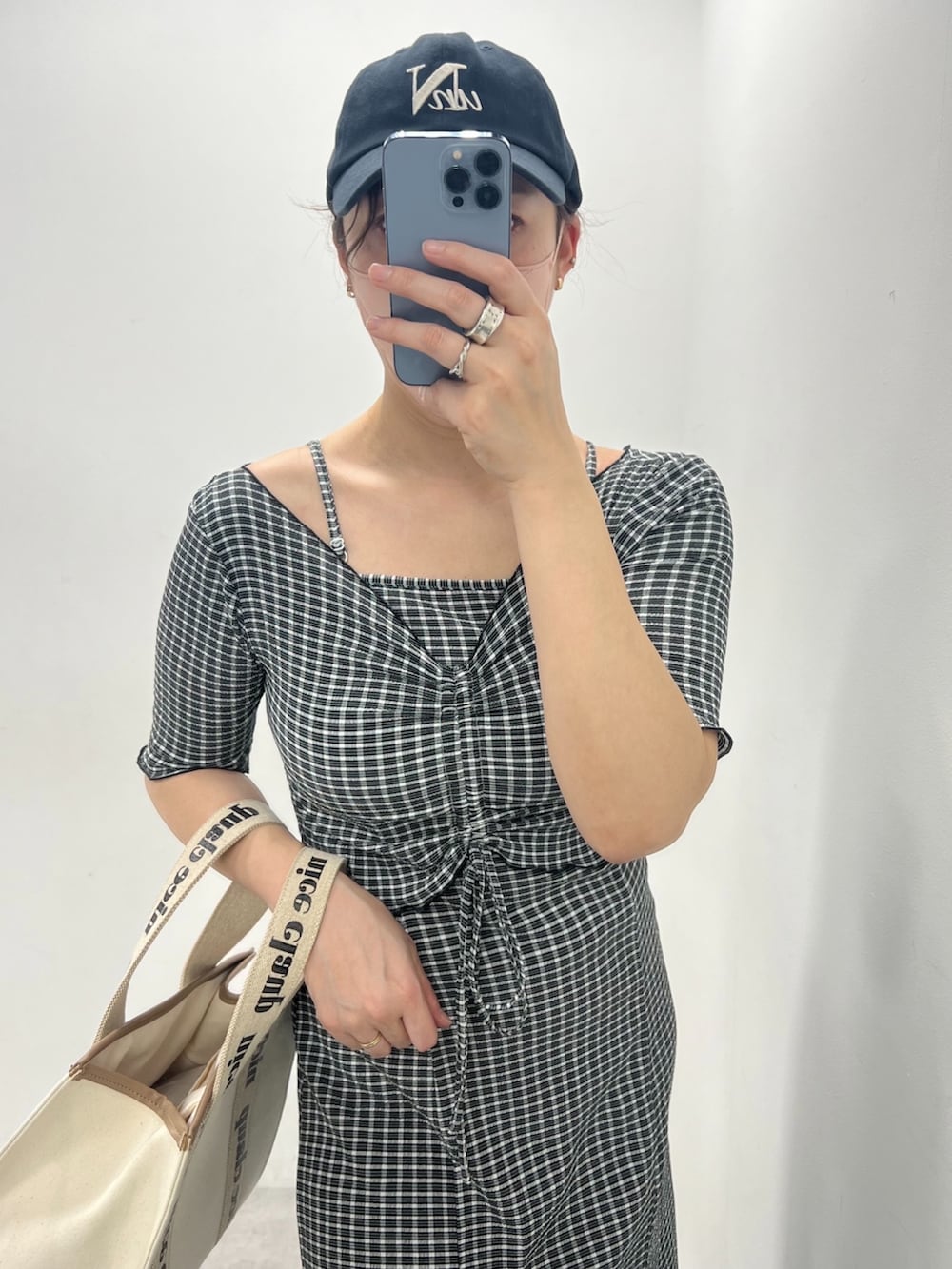 ブラック系のワンピース、ホワイト系のスニーカーを着用したレディースの春コーディネートの2枚目の写真