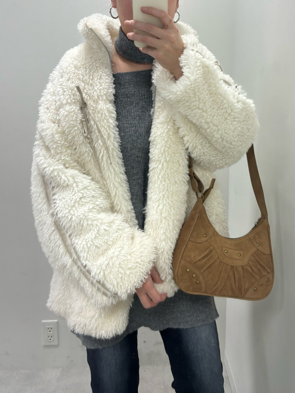 グレー系のワンピース、ホワイト系のパンプス、ベージュ系のショルダーバッグを着用したレディースの冬コーディネートの2枚目の写真