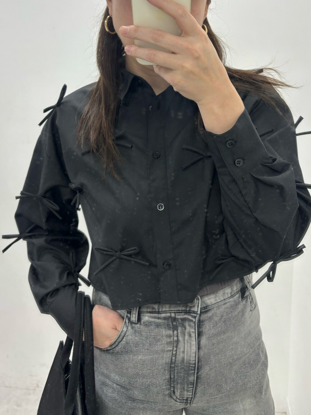 ブラック系のシャツ/ブラウス、ブラック系のデニムパンツ、ブラック系のトートバッグを着用したレディースの冬コーディネートの2枚目の写真