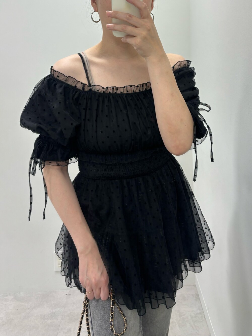 ブラック系のシャツ/ブラウス、シルバー系のサンダル、ブラック系のショルダーバッグを着用したレディースの春コーディネートの2枚目の写真