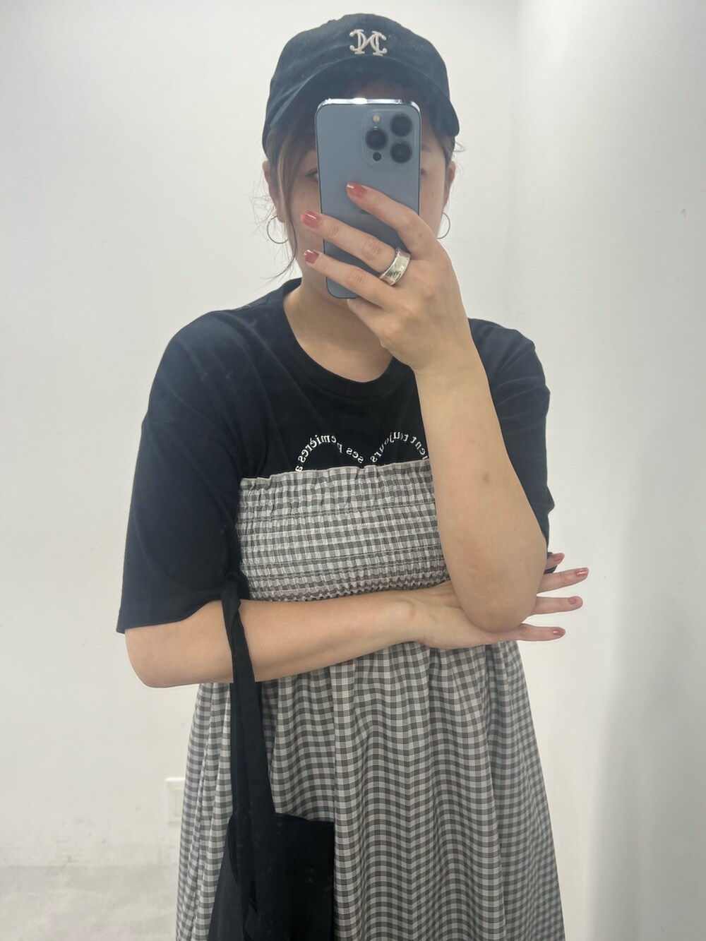 ブラック系のワンピース、ホワイト系のスニーカー、ブラック系のトートバッグを着用したレディースの夏コーディネートの2枚目の写真