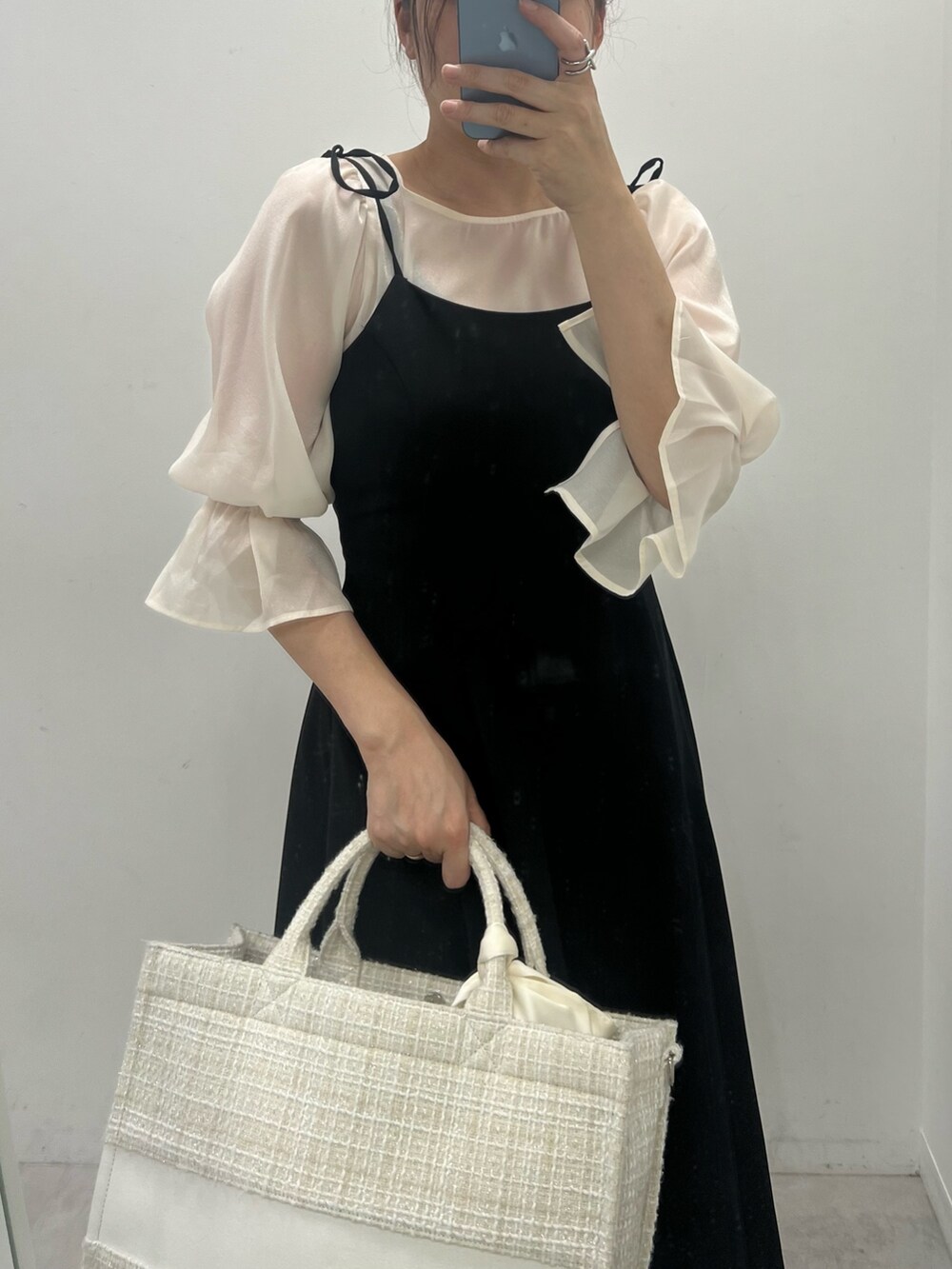 ブラック系のワンピース、ホワイト系のトートバッグ、ホワイト系のシャツ/ブラウスを着用したレディースの夏コーディネートの2枚目の写真