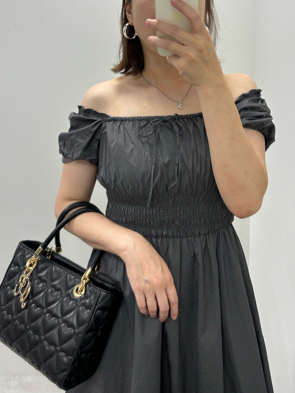 ブラック系のワンピース、ブラック系のサンダル、ブラック系のトートバッグを着用したレディースの夏コーディネートの3枚目の写真