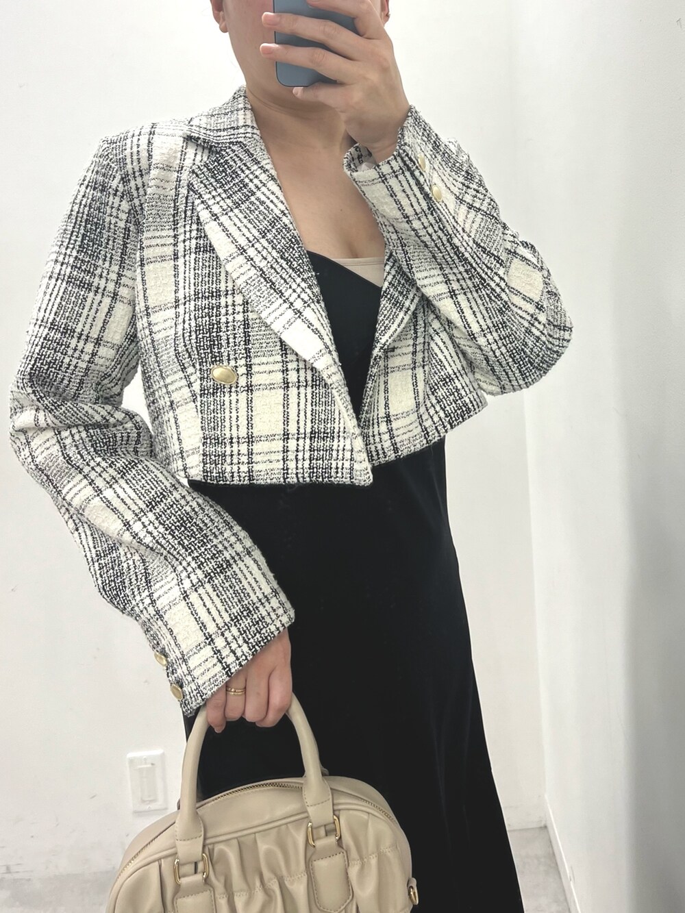 グレー系のボストンバッグ、ブラック系のテーラードジャケット、ホワイト系のワンピースを着用したレディースの春コーディネートの2枚目の写真