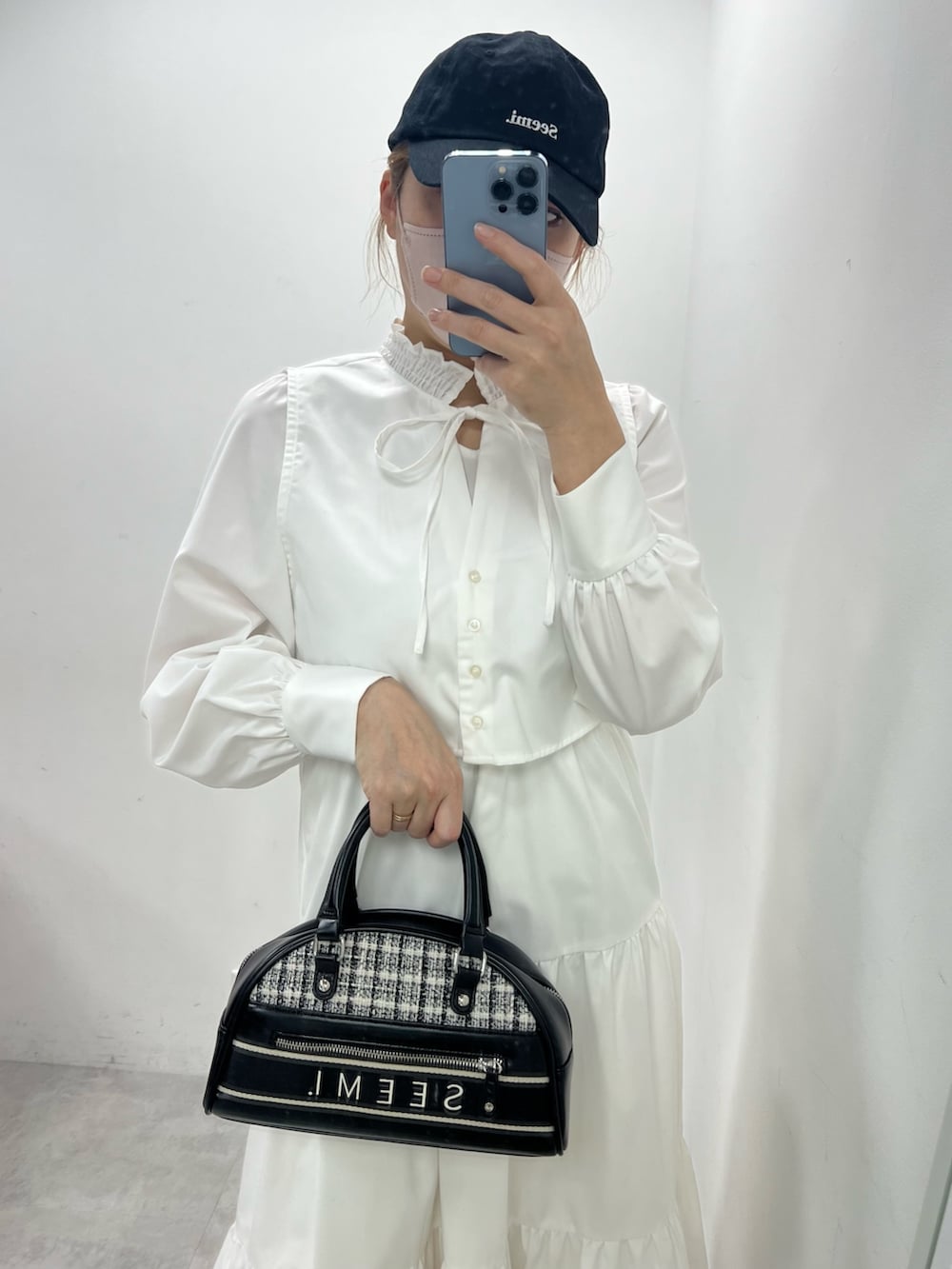 ブルー系のワンピース、ブラック系のブーツ、ブラック系のキャップを着用したレディースの冬コーディネートの2枚目の写真