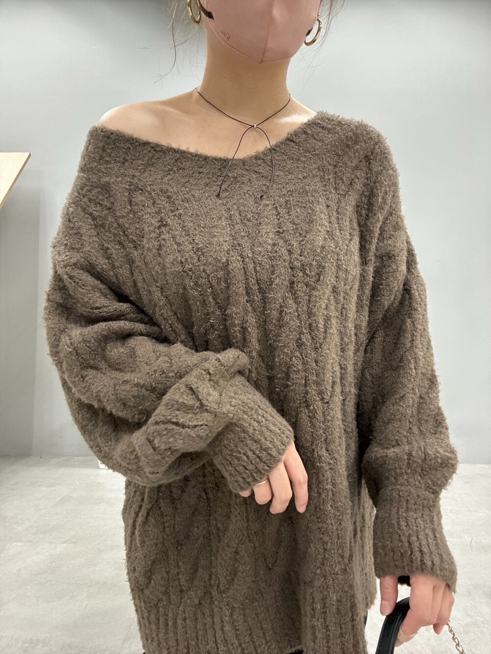 ベージュ系のニット/セーター、ブラック系のスラックス、ブラック系のショルダーバッグを着用したレディースの秋コーディネートの3枚目の写真