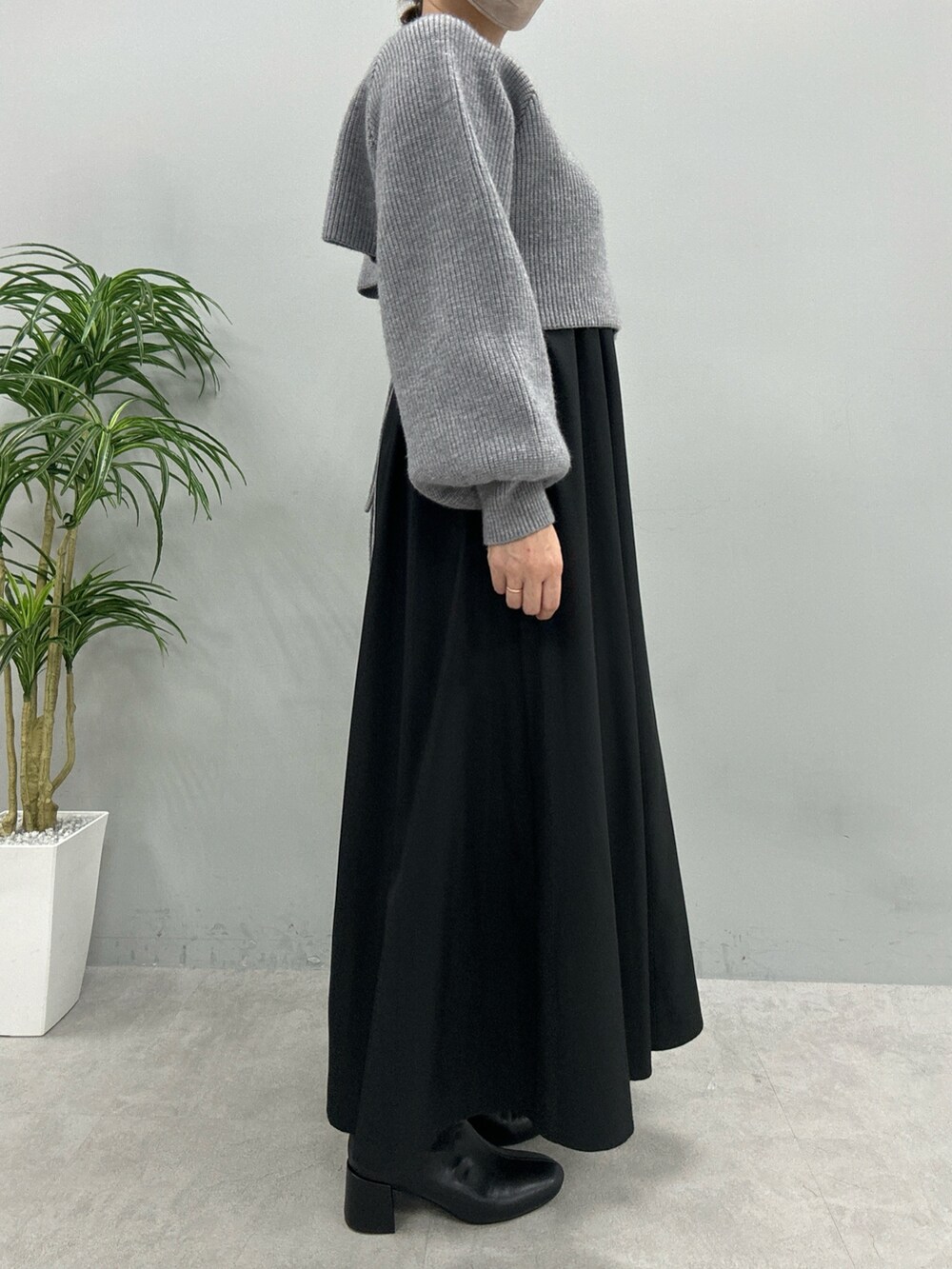 ベージュ系のワンピース、ホワイト系のハンドバッグ、ブラック系のブーツを着用したレディースの秋コーディネートの2枚目の写真