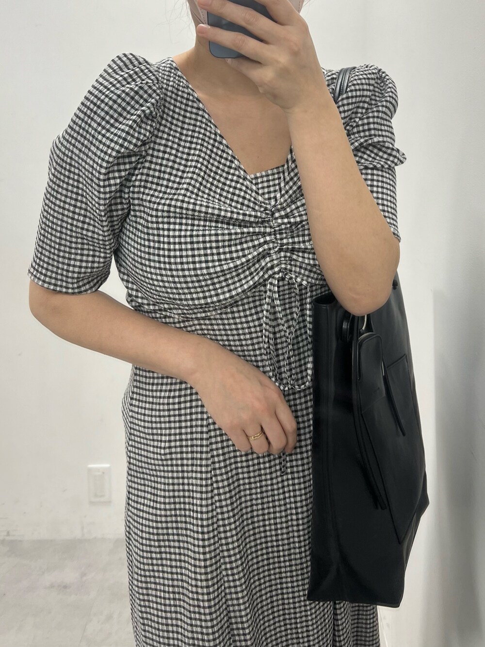 ブラック系のワンピース、ブラック系のトートバッグ、その他のサンダルを着用したレディースの冬コーディネートの2枚目の写真