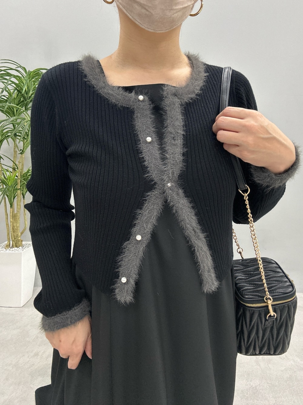 ベージュ系のワンピース、ブラック系のショルダーバッグ、ブラック系のカーディガン/ボレロを着用したレディースの秋コーディネートの4枚目の写真