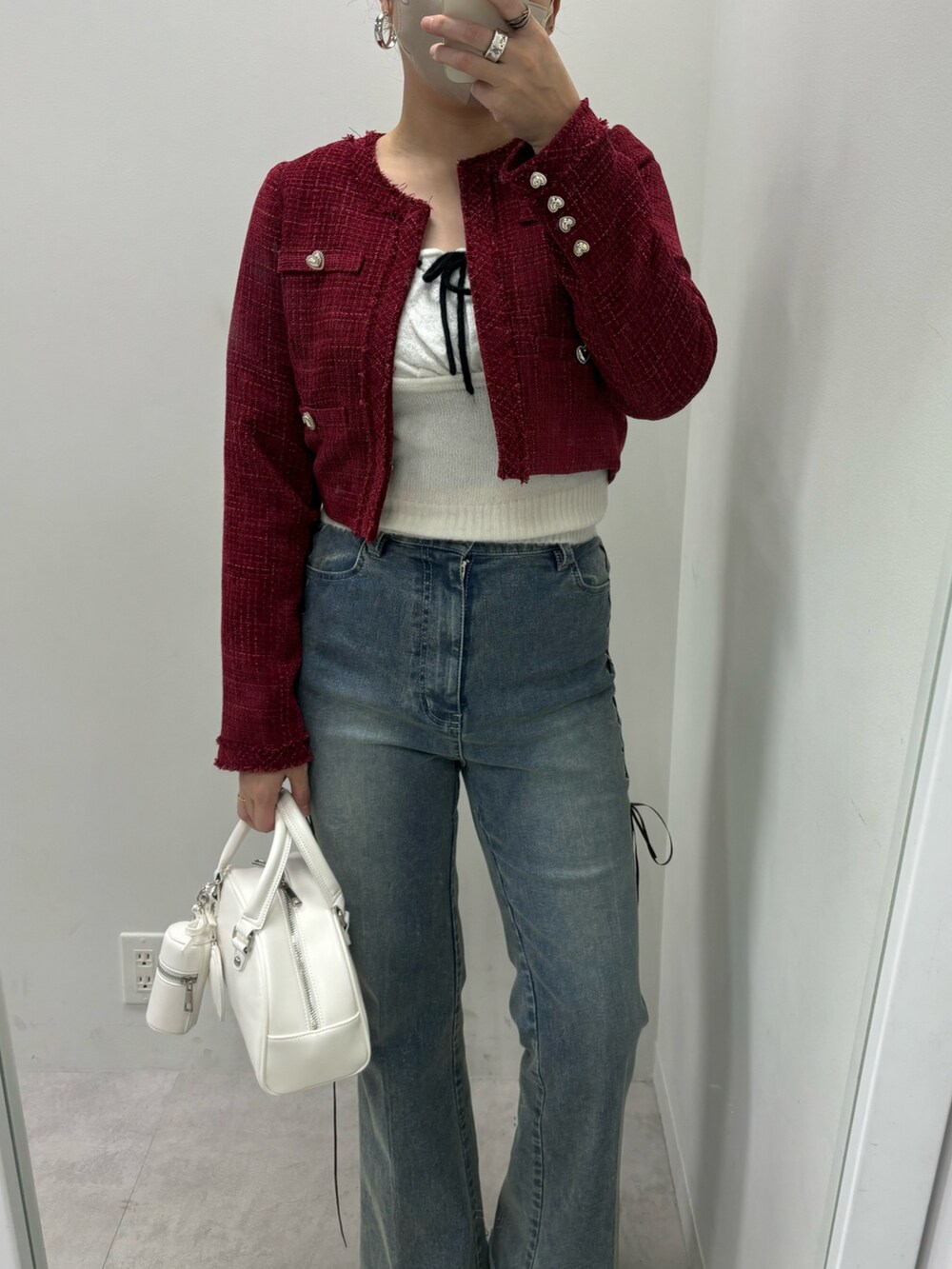 ブルー系のデニムパンツ、ホワイト系のハンドバッグ、レッド系のワンピースを着用したレディースの冬コーディネートの2枚目の写真