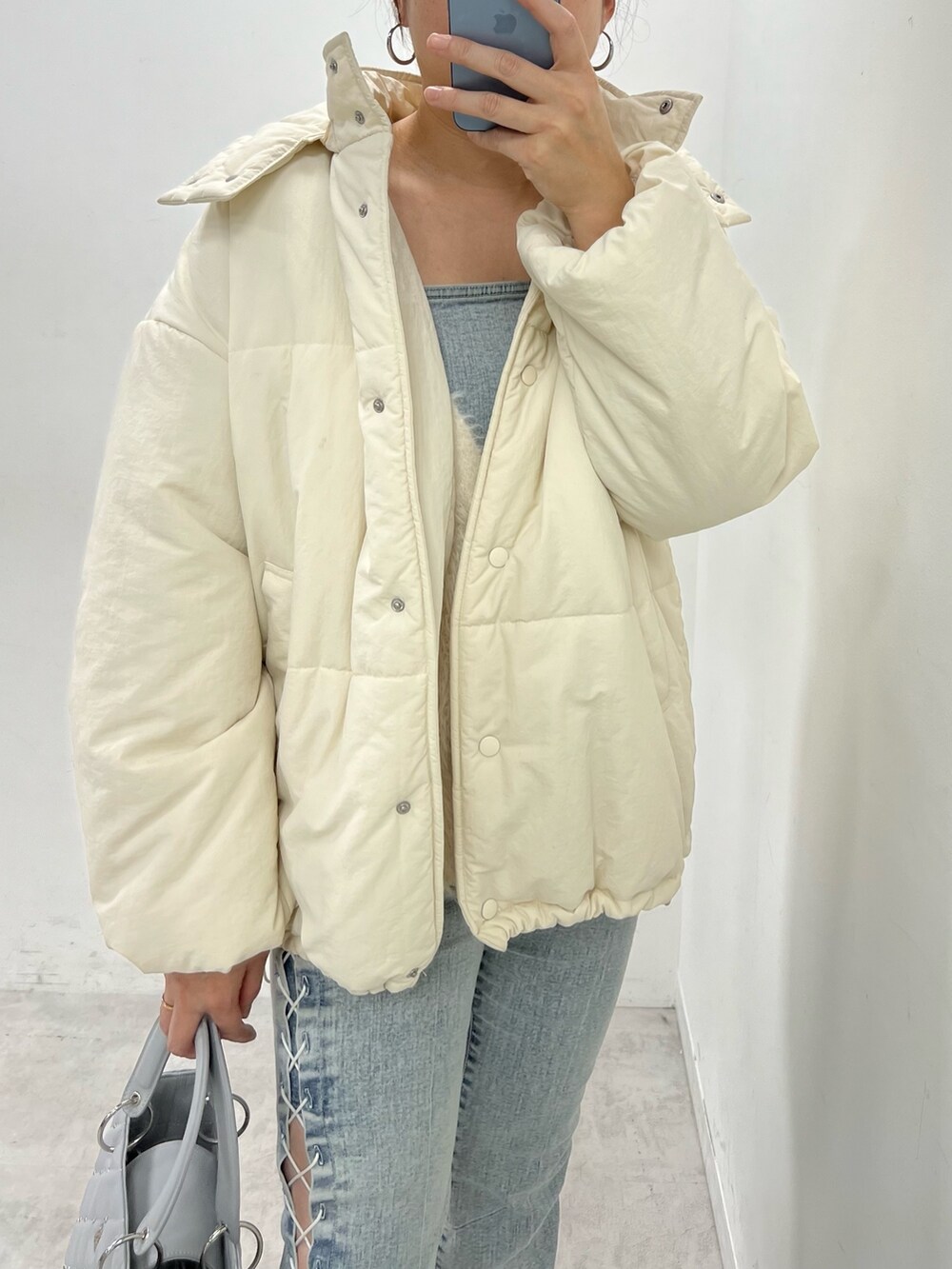 ピンク系のダウンジャケット/コート、ホワイト系のカーディガン/ボレロ、ホワイト系のバレエシューズを着用したレディースの冬コーディネートの2枚目の写真