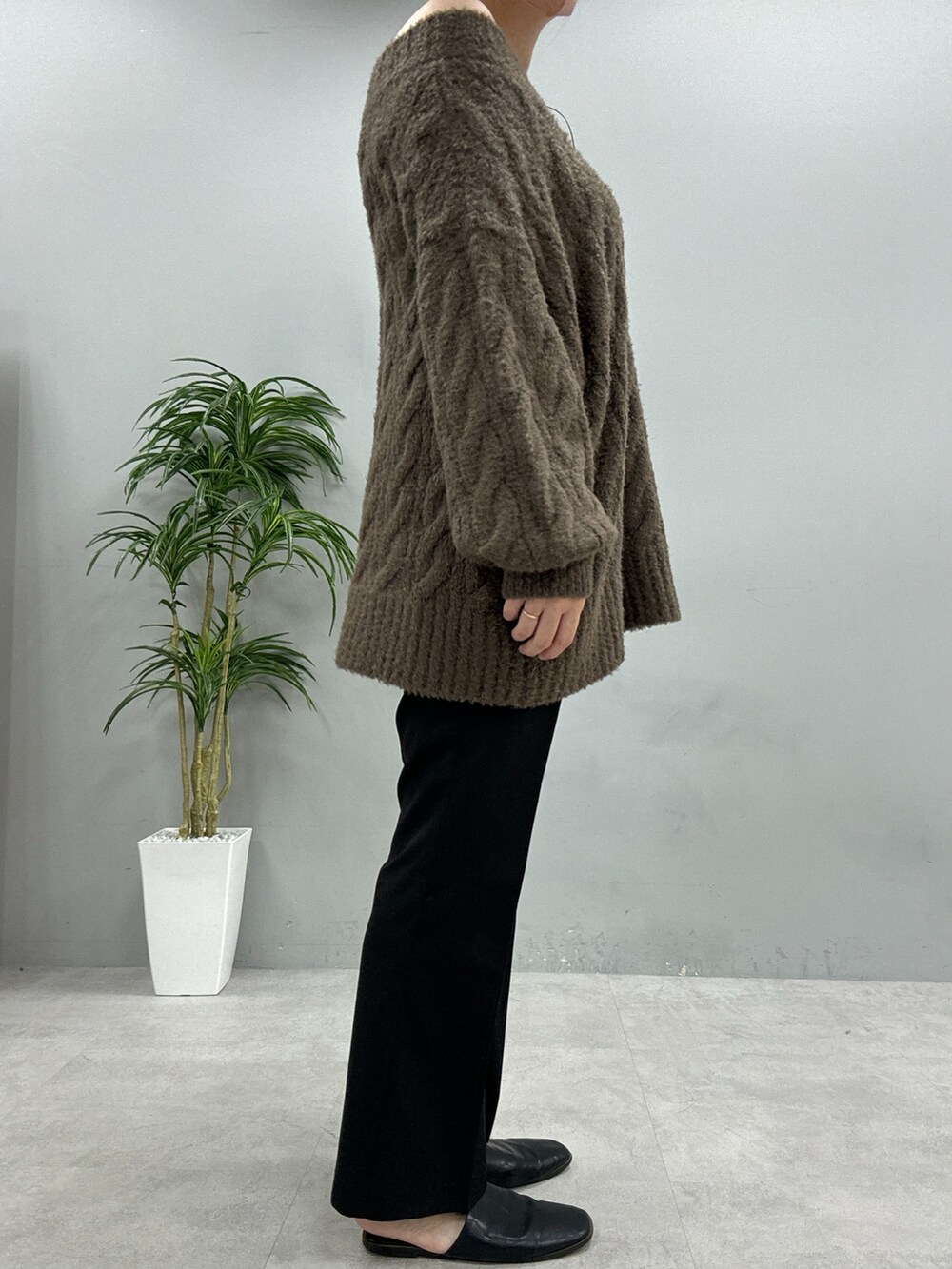 ベージュ系のニット/セーター、ブラック系のスラックス、ブラック系のショルダーバッグを着用したレディースの秋コーディネートの2枚目の写真