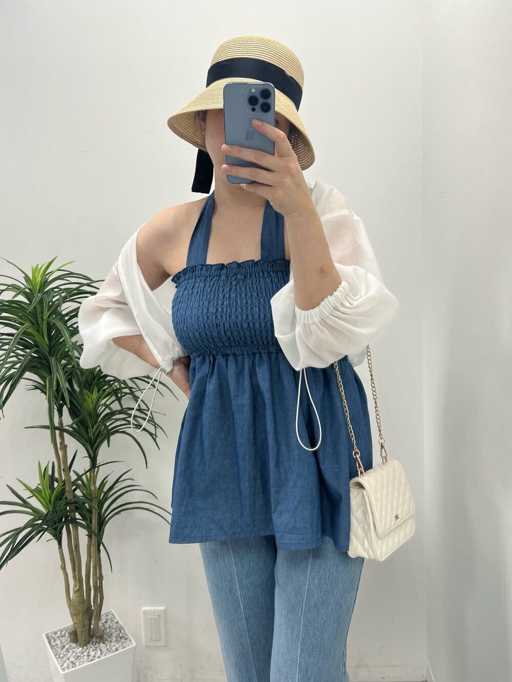 ブルー系のキャミソール、ブルー系のデニムパンツ、ホワイト系のサンダルを着用したレディースの春コーディネートの2枚目の写真