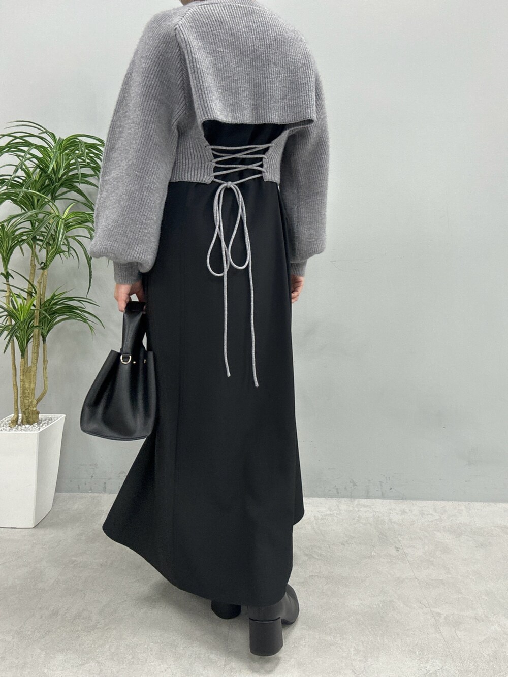 ベージュ系のワンピース、ホワイト系のハンドバッグ、ブラック系のブーツを着用したレディースの秋コーディネートの3枚目の写真