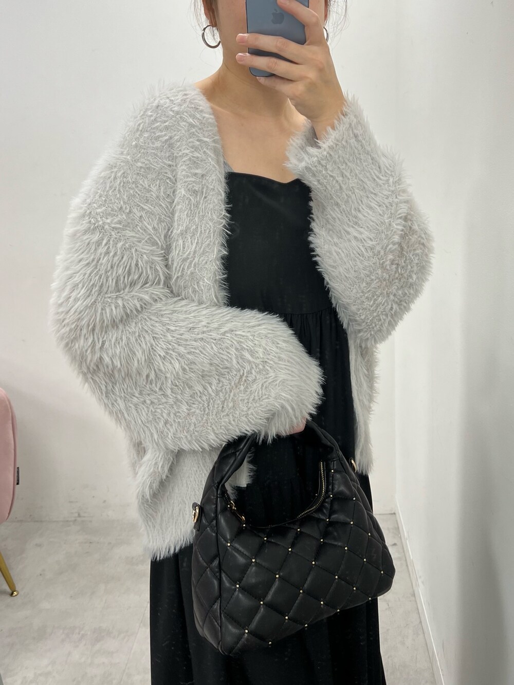 グレー系のカーディガン/ボレロ、ホワイト系のショルダーバッグ、ブラック系のバレエシューズを着用したレディースの冬コーディネートの2枚目の写真