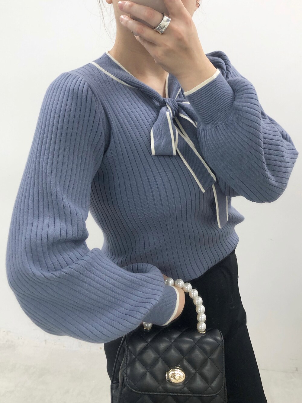 ブルー系のニット/セーター、グリーン系のスラックス、ブラック系のブーツを着用したレディースの秋コーディネートの2枚目の写真