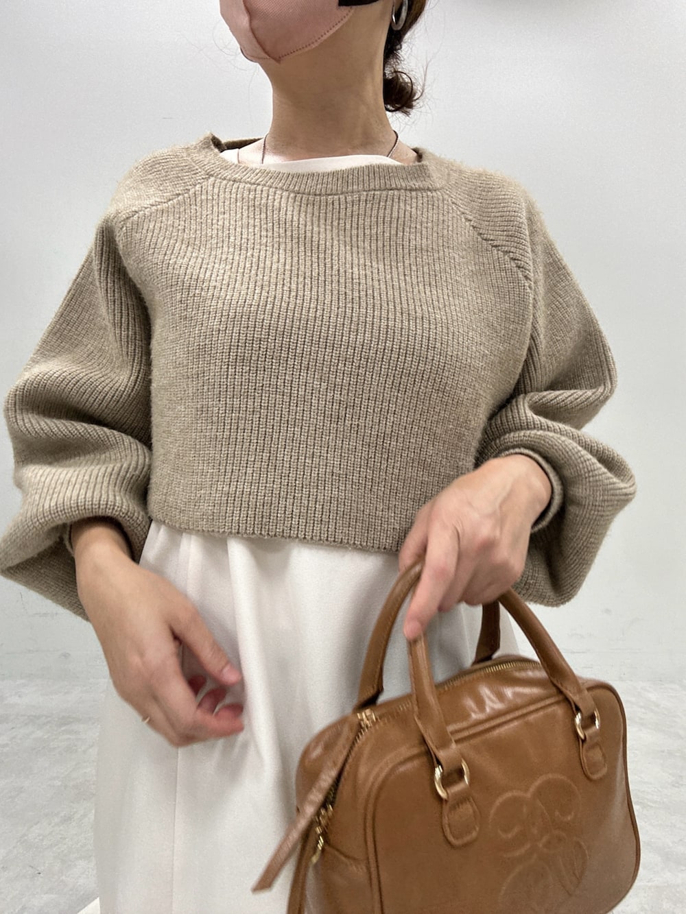 ブラック系のブーツ、ベージュ系のワンピース、イエロー系のボストンバッグを着用したレディースの秋コーディネートの4枚目の写真