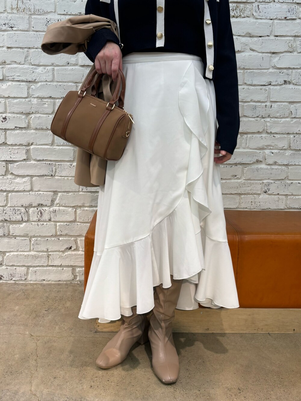 イエロー系のボストンバッグ、ブルー系のキャミソール、ブルー系のカーディガン/ボレロを着用したレディースの冬コーディネートの4枚目の写真