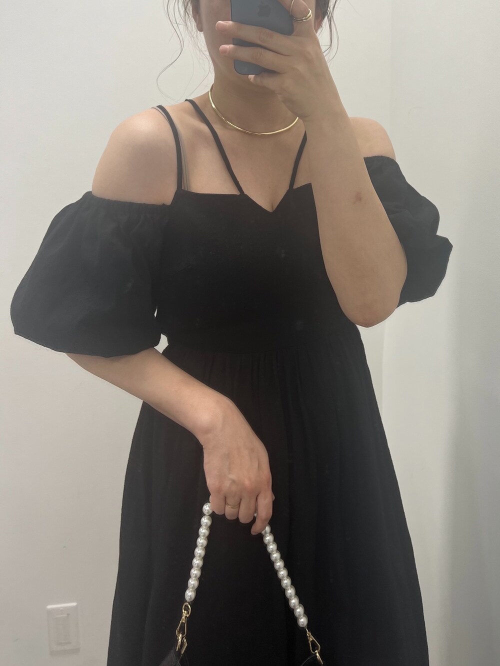 ブラウン系のサンダル、ホワイト系のショルダーバッグ、ブラック系のワンピースを着用したレディースの春コーディネートの2枚目の写真