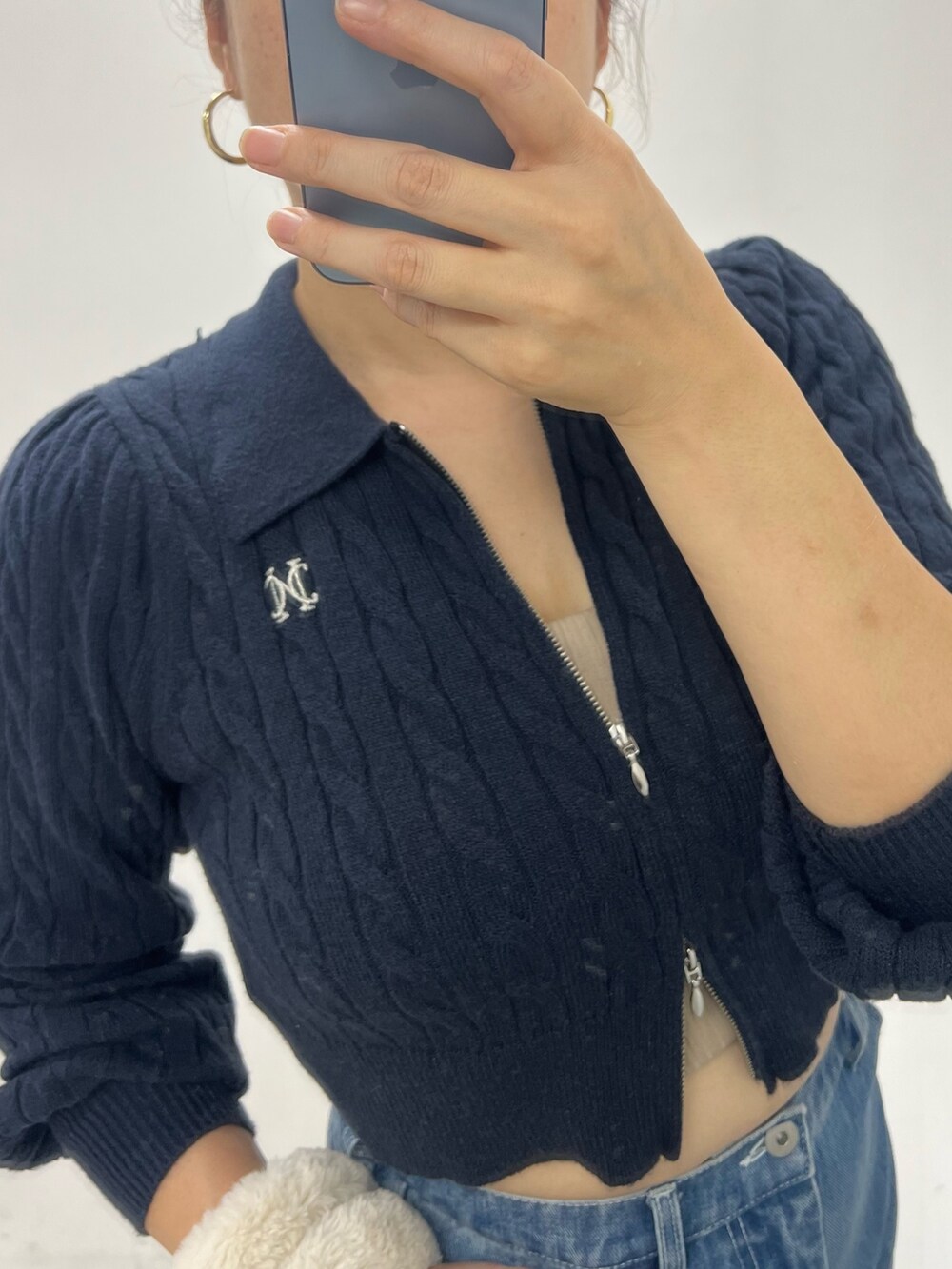 ブルー系のデニムパンツ、ブルー系のニット/セーター、ホワイト系のスニーカーを着用したレディースの秋コーディネートの3枚目の写真