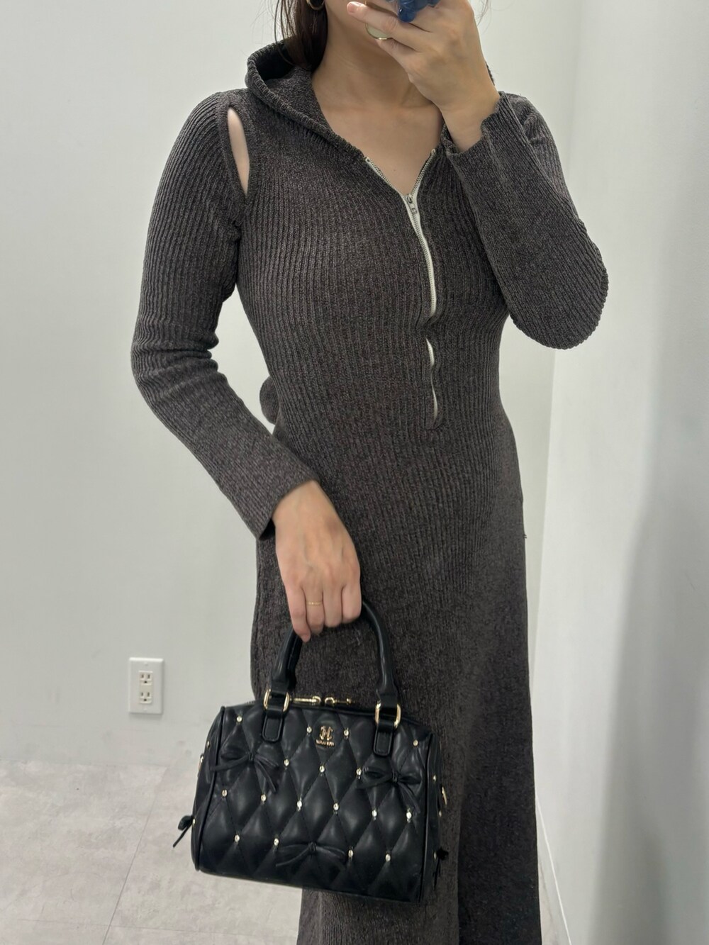 グレー系のワンピース、ブラック系のボストンバッグ、ブラック系のブーツを着用したレディースの秋コーディネートの4枚目の写真