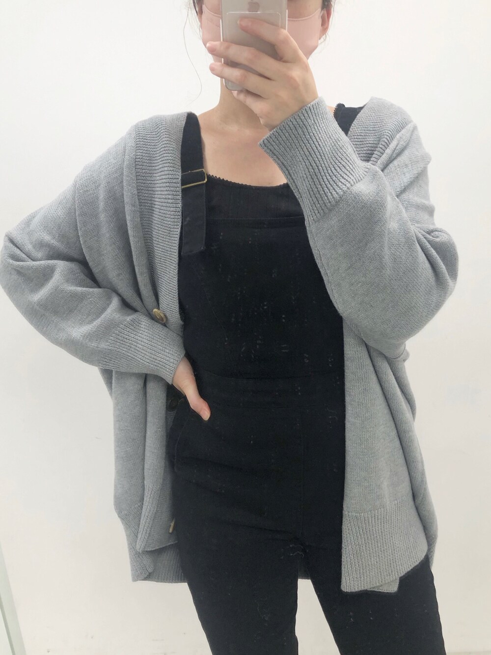 ブラック系のサロペット/オーバーオール、ホワイト系のスニーカー、グレー系のカーディガン/ボレロを着用したレディースの秋コーディネートの2枚目の写真