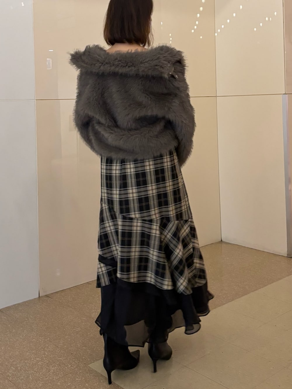 ブラック系のハンドバッグ、ブラウン系のブルゾン、ブラウン系のワンピースを着用したレディースの冬コーディネートの2枚目の写真