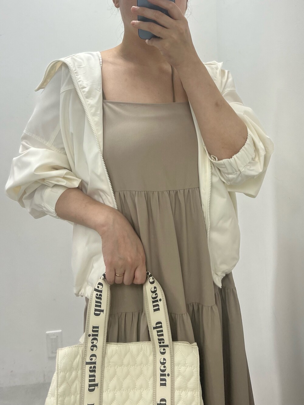 ベージュ系のワンピース、ホワイト系のサンダル、ホワイト系のトートバッグを着用したレディースの夏コーディネートの2枚目の写真