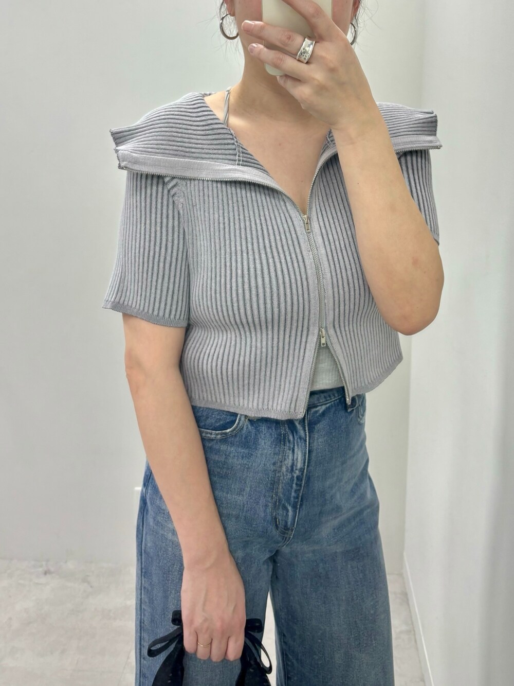 ブルー系のデニムパンツ、グレー系のニット/セーターを着用したレディースの春コーディネートの2枚目の写真