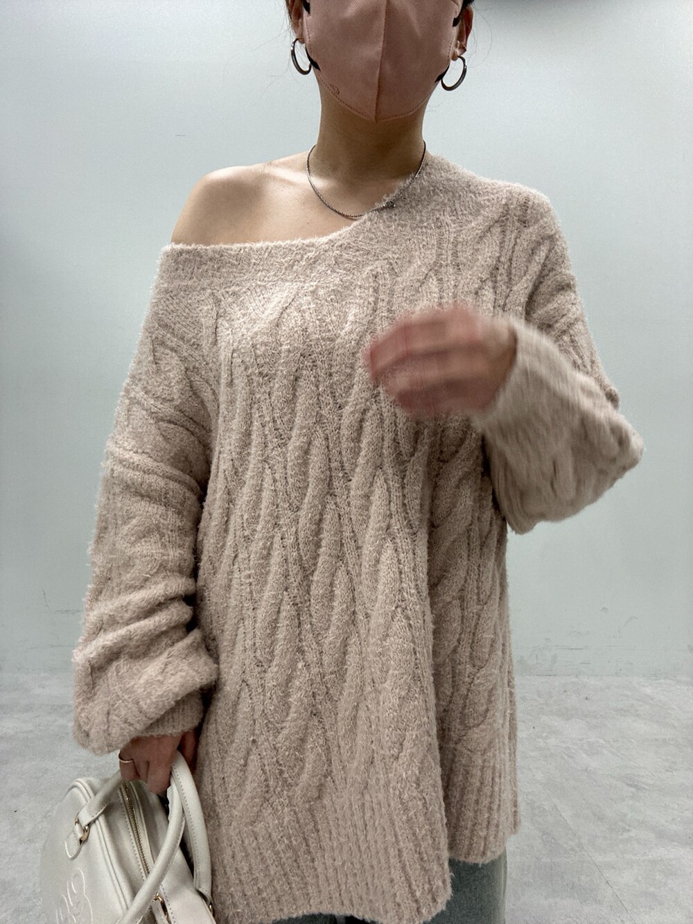 ブルー系のデニムパンツ、ベージュ系のニット/セーター、ブラック系のブーツを着用したレディースの秋コーディネートの4枚目の写真