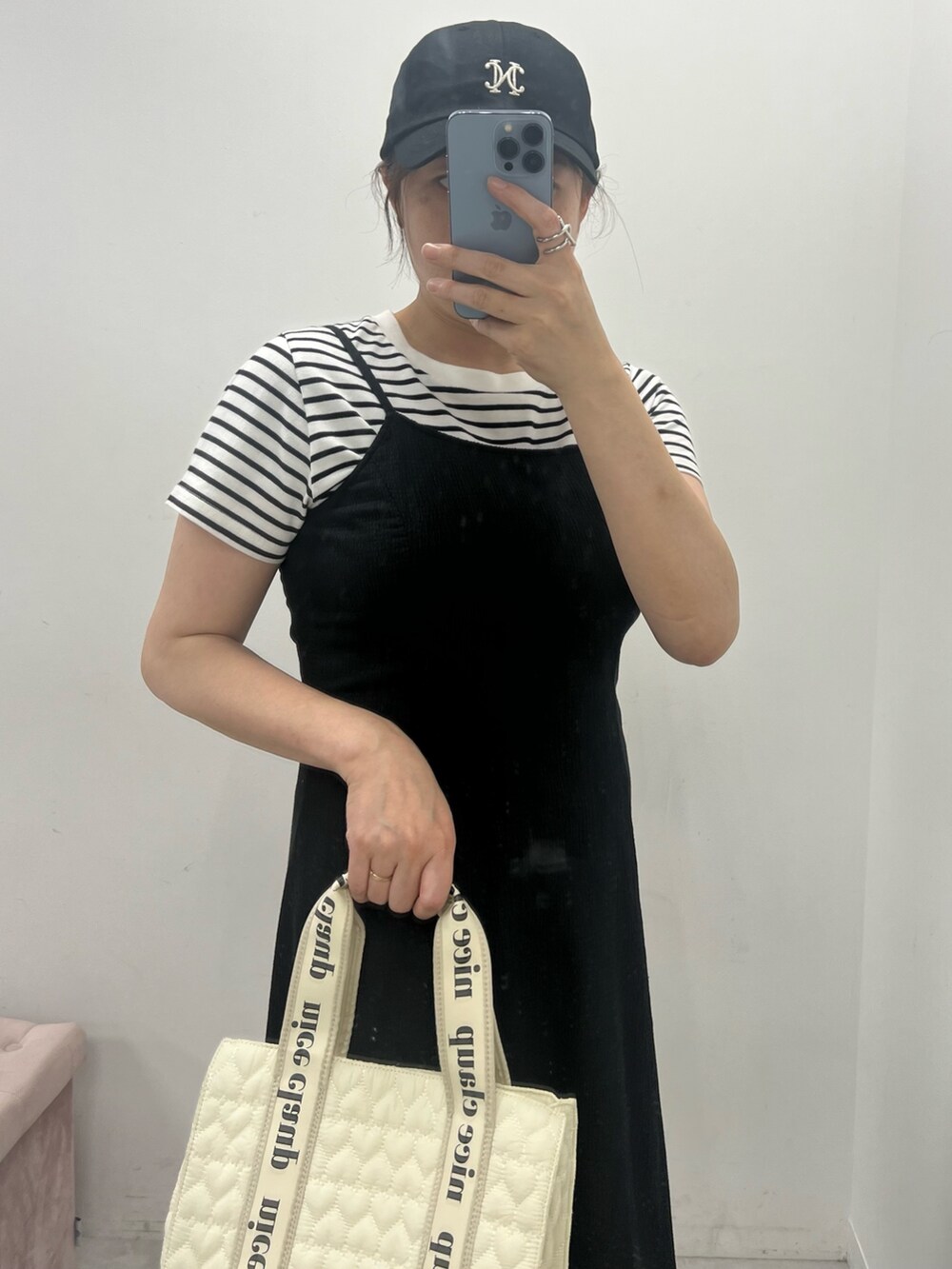 ホワイト系のトートバッグ、ブラック系のワンピース、ホワイト系のTシャツ/カットソーを着用したレディースの夏コーディネートの2枚目の写真