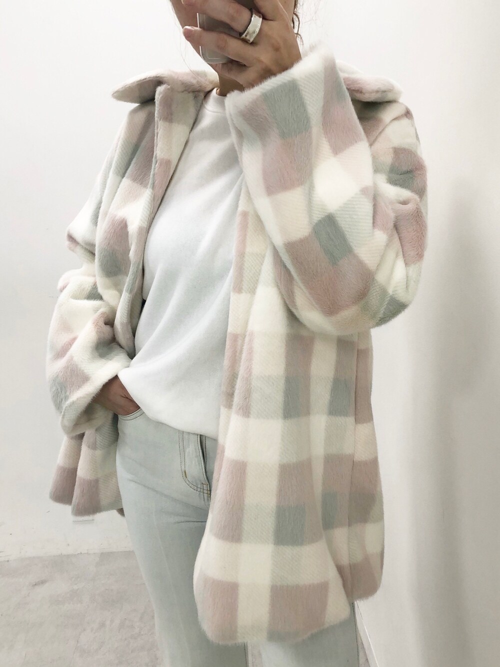 ブルー系のデニムパンツ、ピンク系のチェスターコート、ホワイト系のTシャツ/カットソーを着用したレディースの秋コーディネートの3枚目の写真