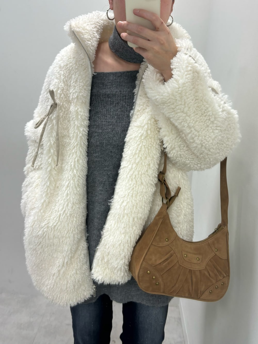 グレー系のワンピース、ホワイト系のパンプス、ベージュ系のショルダーバッグを着用したレディースの冬コーディネートの4枚目の写真