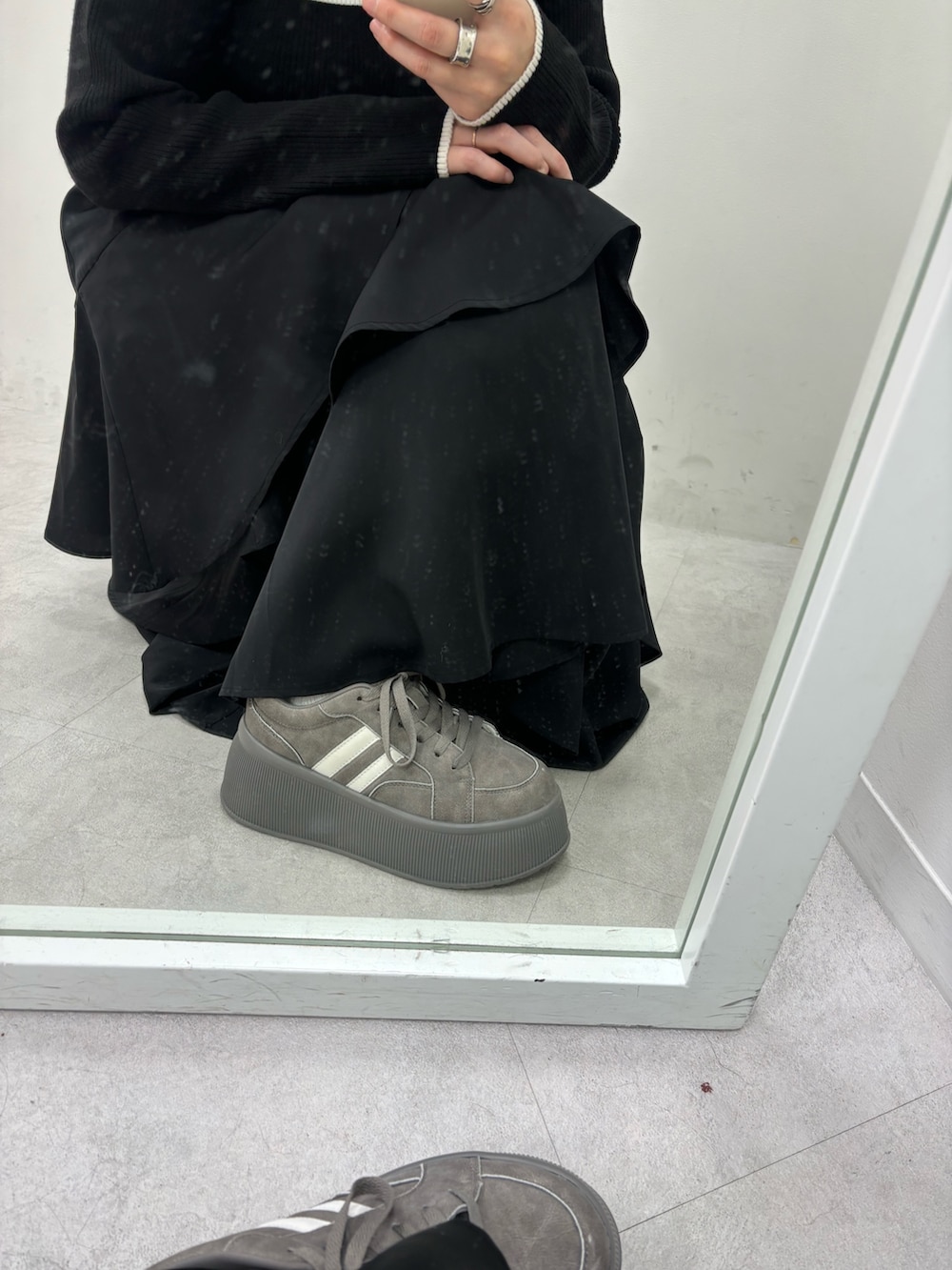 ブラック系のスカート、ブラック系のニット/セーター、グレー系のスニーカーを着用したレディースの秋コーディネートの7枚目の写真