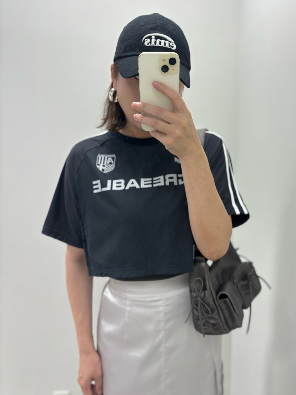 グレー系のスカート、ブラック系のサンダル、ブラック系のショルダーバッグを着用したレディースの夏コーディネートの2枚目の写真