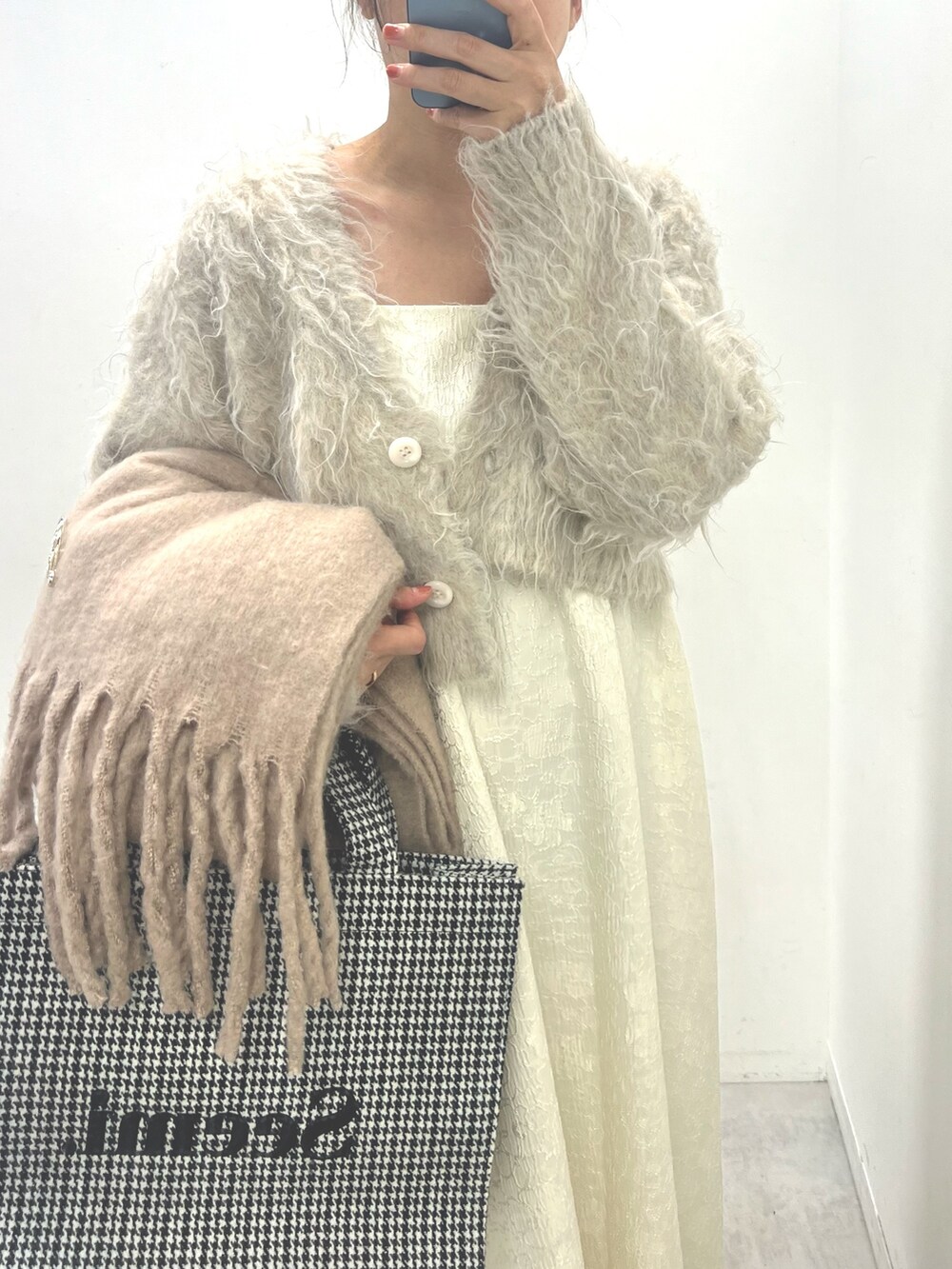 ホワイト系のワンピース、ブラック系のブーツ、ホワイト系のトートバッグを着用したレディースの夏コーディネートの2枚目の写真