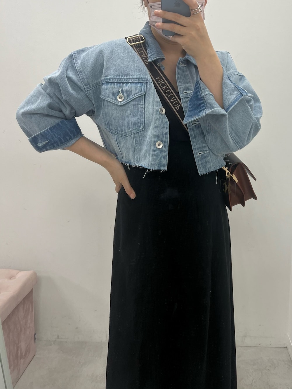 オレンジ系のワンピース、ブルー系のデニムジャケット、ブラウン系のショルダーバッグを着用したレディースの夏コーディネートの2枚目の写真