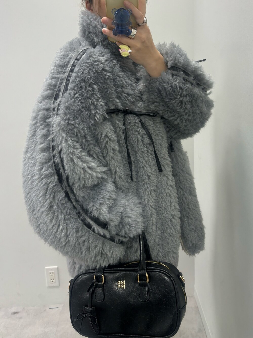 ブルー系のデニムパンツ、ブラック系のショルダーバッグ、グレー系のブルゾンを着用したレディースの秋コーディネートの6枚目の写真