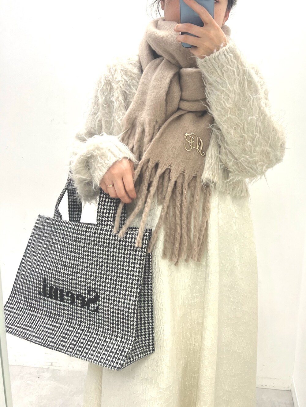 ホワイト系のワンピース、ブラック系のブーツ、ホワイト系のトートバッグを着用したレディースの夏コーディネートの4枚目の写真