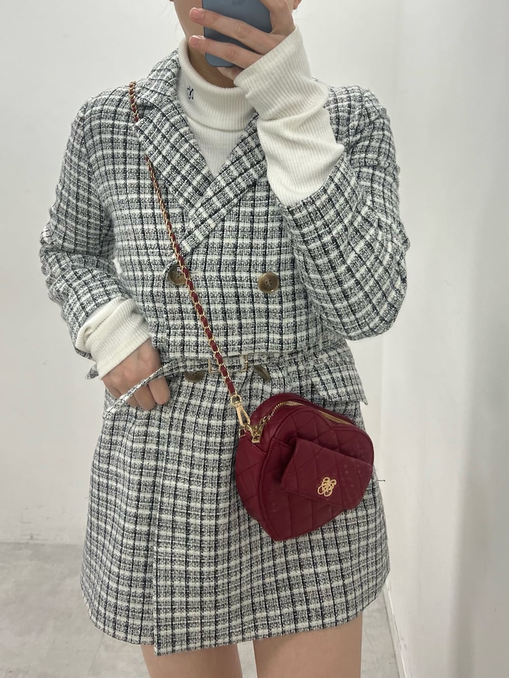 ホワイト系のテーラードジャケット、レッド系のショルダーバッグ、ホワイト系のTシャツ/カットソーを着用したレディースの冬コーディネートの2枚目の写真