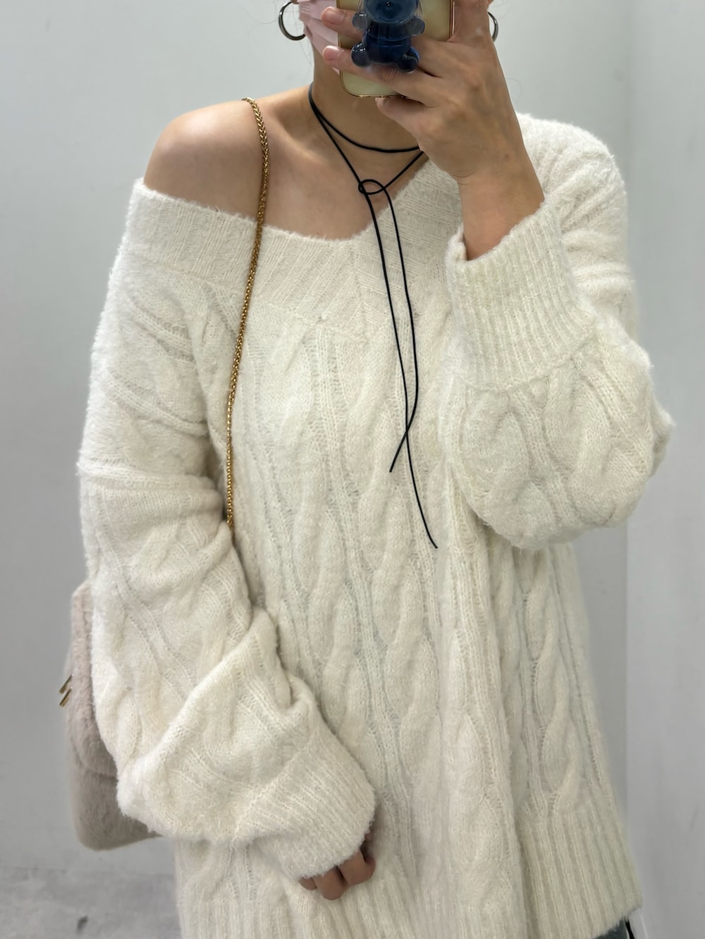 ブルー系のデニムパンツ、ベージュ系のニット/セーター、ブラック系のブーツを着用したレディースの秋コーディネートの4枚目の写真