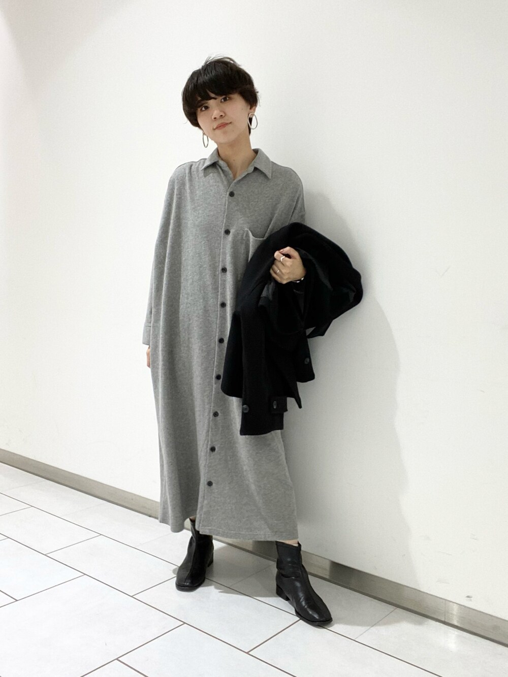 グレー系のワンピース、ブラック系のブーツを着用したレディースの冬コーディネートの2枚目の写真