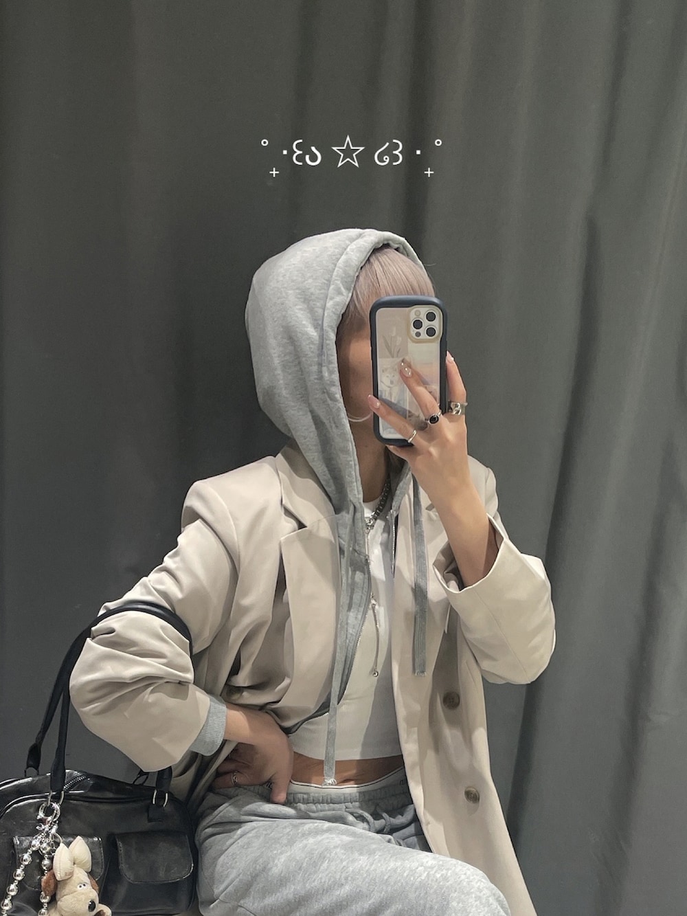 ベージュ系のテーラードジャケット、ホワイト系のタンクトップ、グレー系のパーカーを着用したレディースの夏コーディネートの4枚目の写真