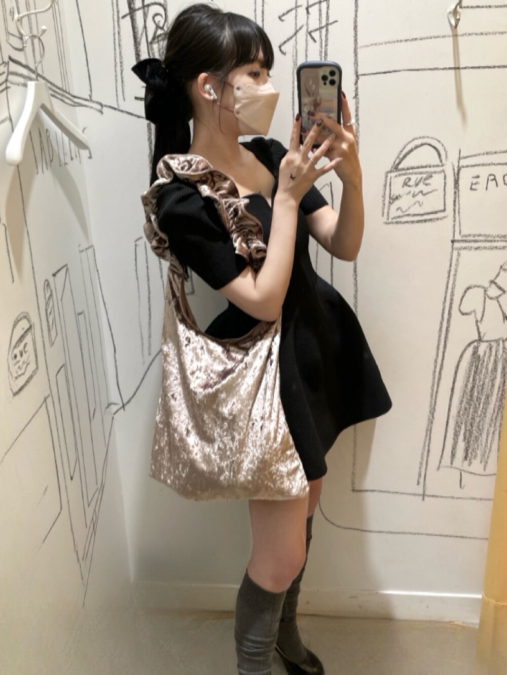 ブラック系のトップス、ピンク系のバッグ、ブラック系のパンプスを着用したレディースの冬コーディネートの2枚目の写真