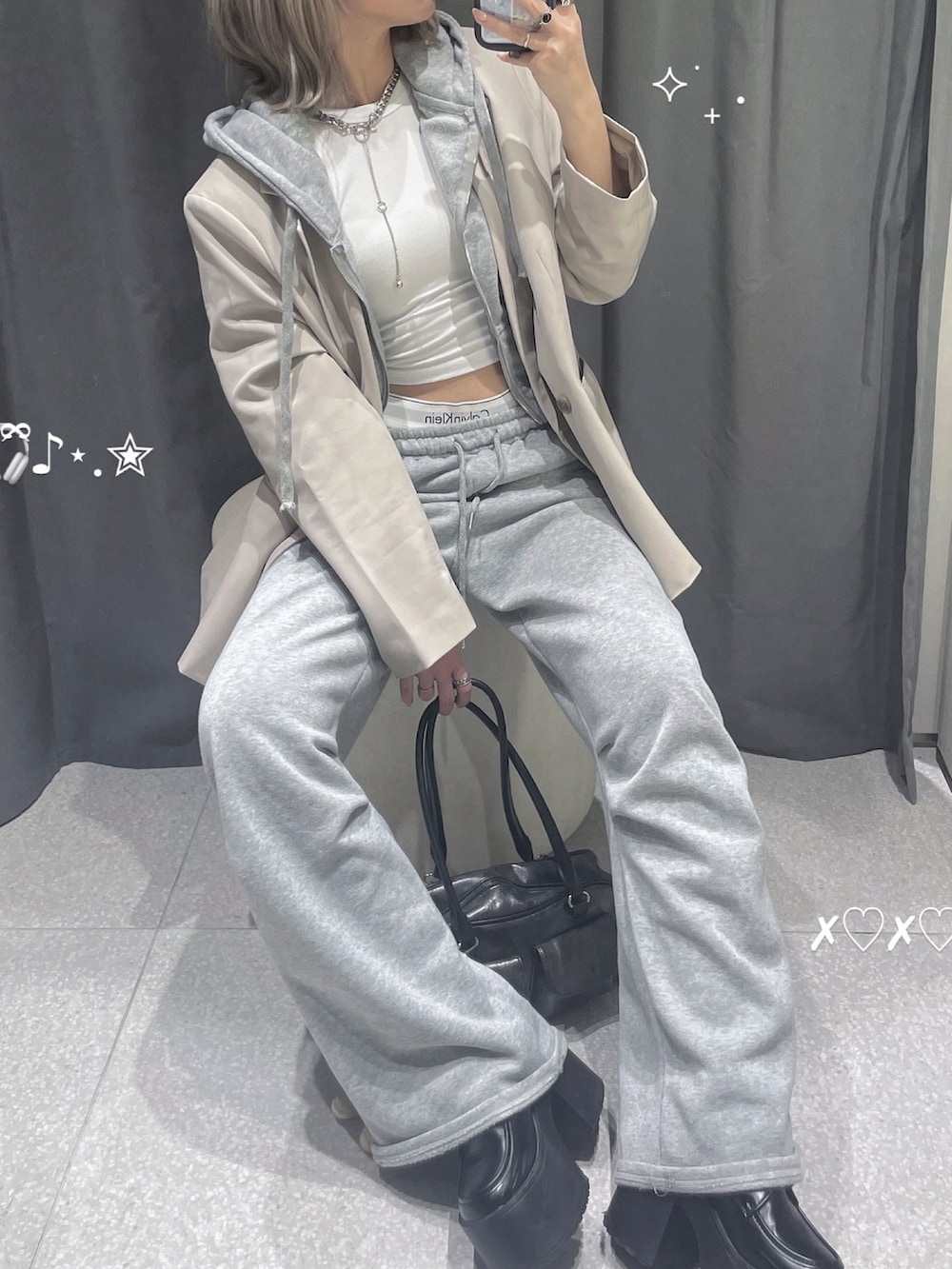 ベージュ系のテーラードジャケット、ホワイト系のタンクトップ、グレー系のパーカーを着用したレディースの夏コーディネートの3枚目の写真